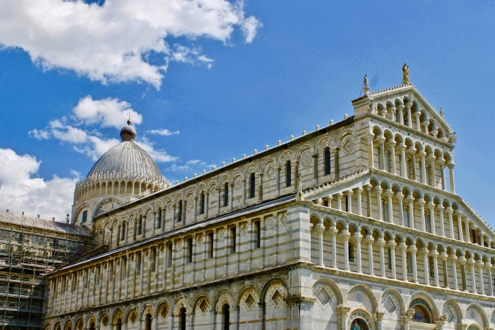 Ornate cathedral facade under a blue sky with clouds.